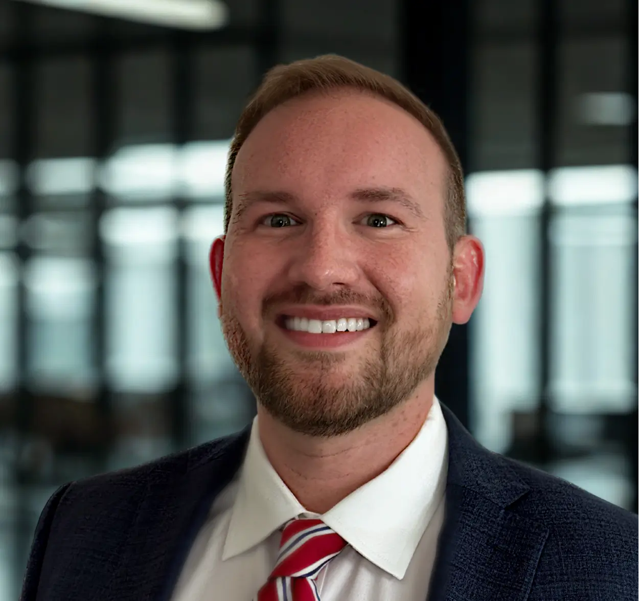 Smiling man in suit and tie indoors.